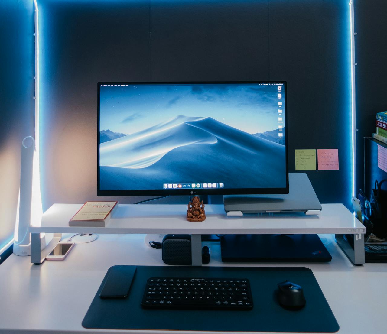 Services-01 Modern desk setup with illuminated monitor, keyboard, mouse, and neat arrangement under soft neon lights.
